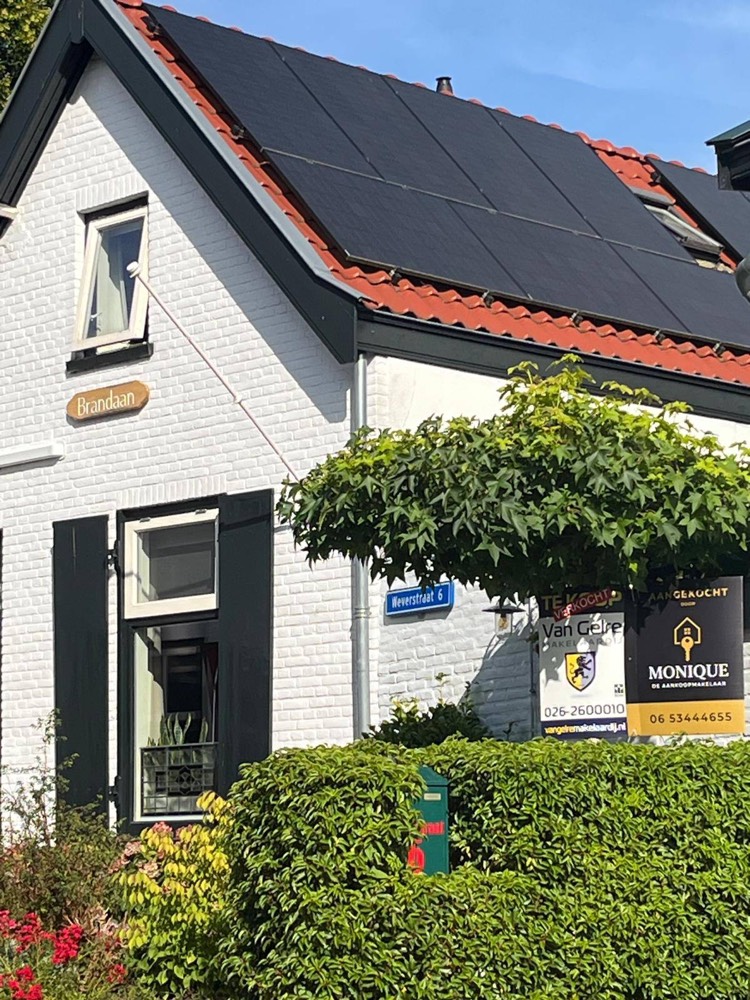 Het bord Aangekocht door Monique bij een woning aan de Weverstraat in Oosterbeek